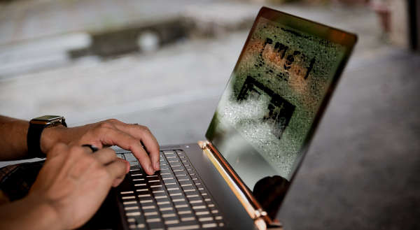 ノートパソコンを操作する男性の手